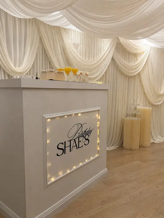Fairy-lit bar front with custom birthday signage
